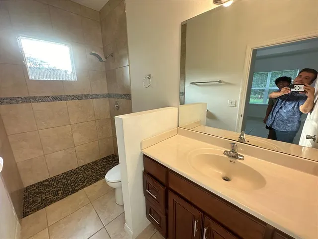 a bathroom with a sink a toilet and shower