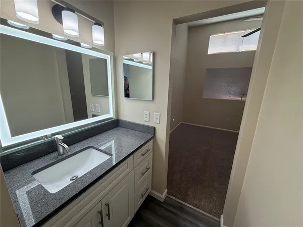 a bathroom with a granite countertop sink and mirror