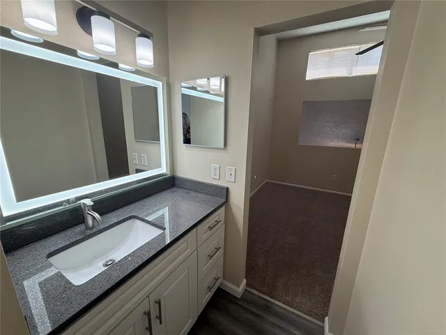 a bathroom with a granite countertop sink and mirror