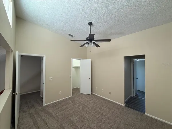 a view of a room with a ceiling fan and a window