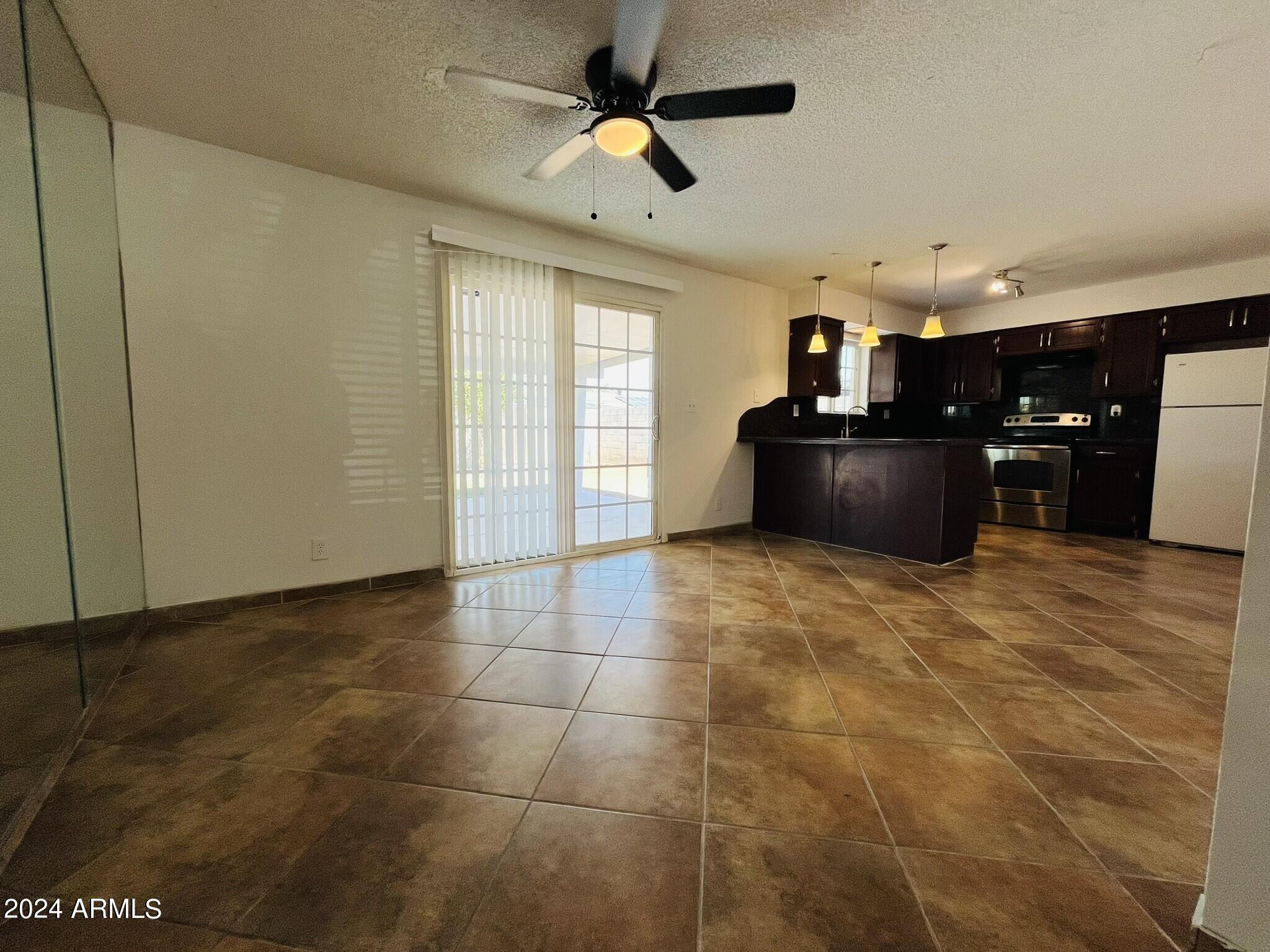 5154 West Berkeley Road Phoenix, AZ 85035 - Photo 6 of 19 a living room with stainless steel appliances kitchen island granite countertop a sink cabinets and wooden floor