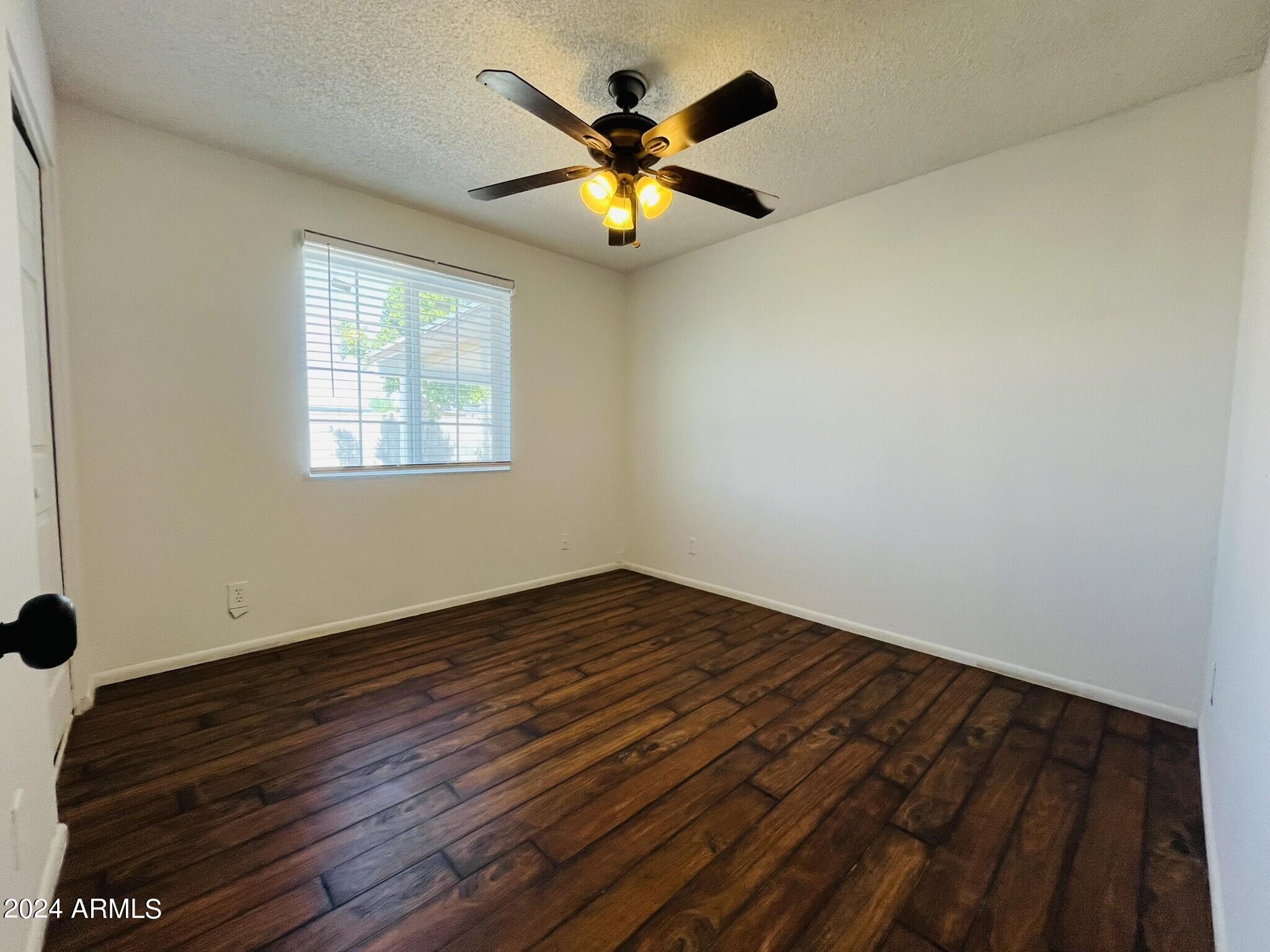5154 West Berkeley Road Phoenix, AZ 85035 - Photo 9 of 19 wooden floor in an empty room with a window