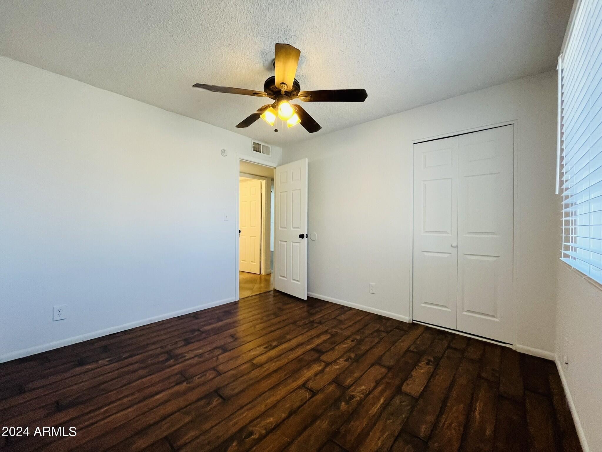 5154 West Berkeley Road Phoenix, AZ 85035 - Photo 10 of 19 wooden floor in an empty room with a window