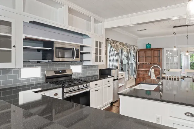 a kitchen with a sink appliances and cabinets