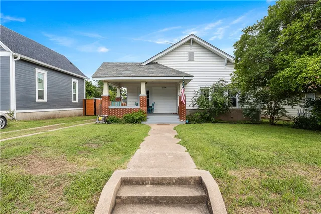 a front view of a house with a yard and garden
