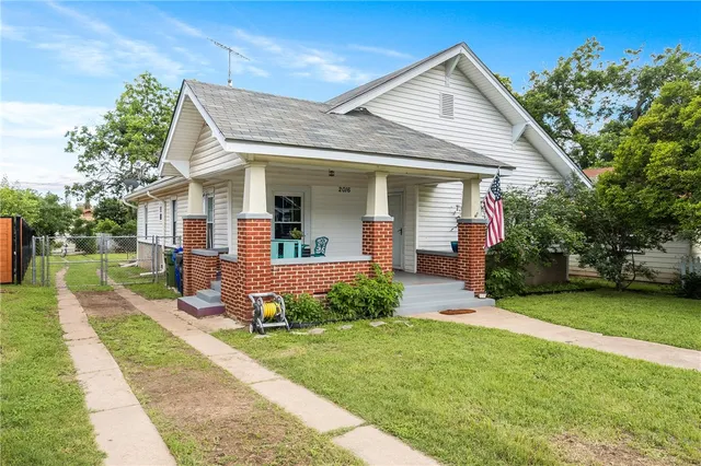 a front view of a house with a yard and potted plants