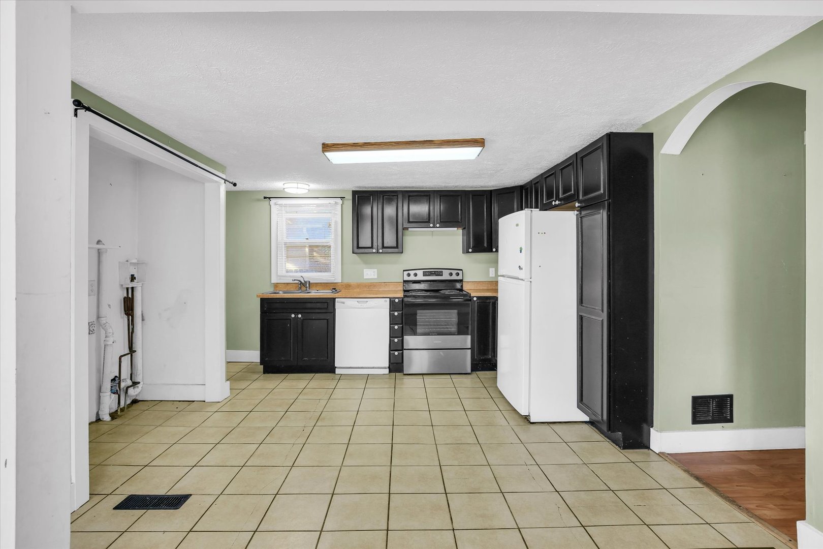 107 Byron Street Sidney, IL 61877 - Photo 11 of 31 a kitchen with a refrigerator a stove top oven and cabinets
