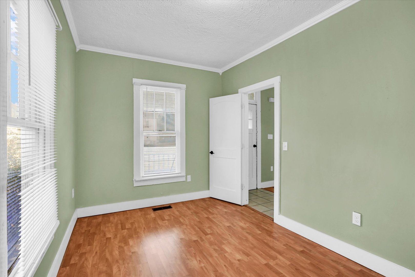 107 Byron Street Sidney, IL 61877 - Photo 18 of 31 an empty room with wooden floor and windows