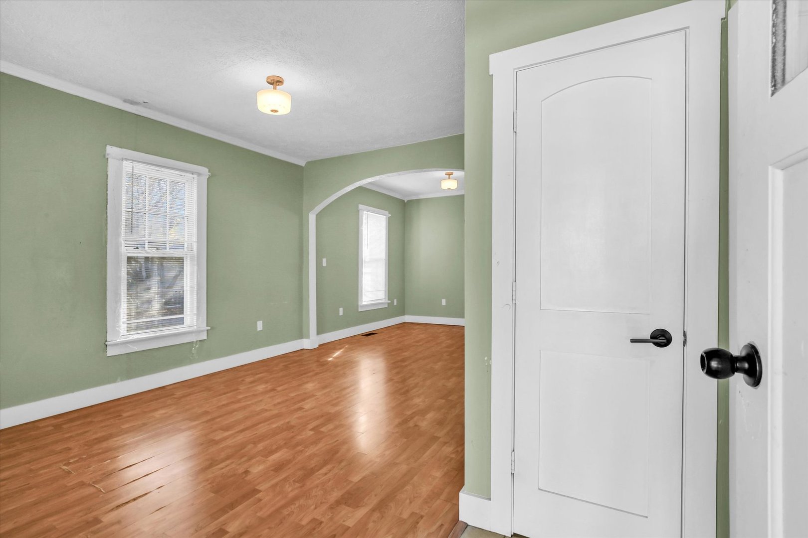 107 Byron Street Sidney, IL 61877 - Photo 5 of 31 an empty room with wooden floor and a window