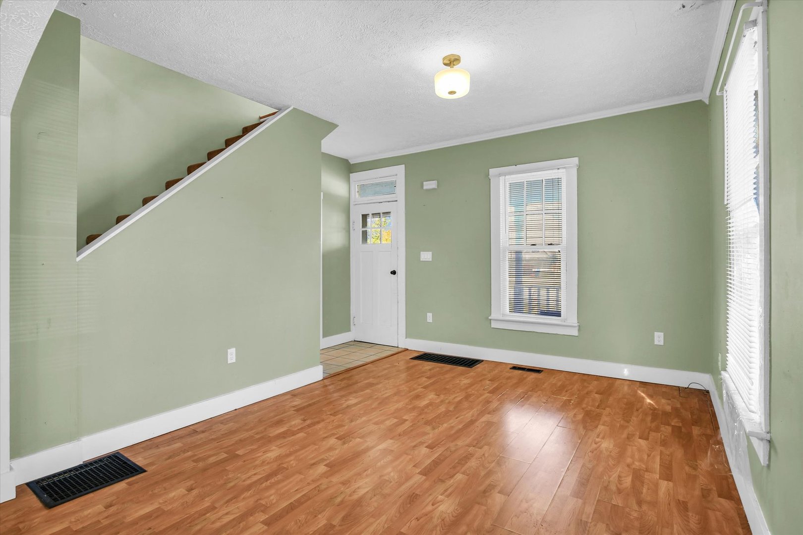 107 Byron Street Sidney, IL 61877 - Photo 6 of 31 an empty room with wooden floor and windows