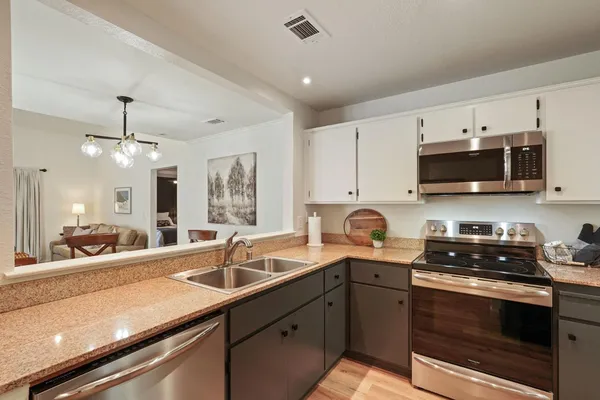 a kitchen with stainless steel appliances a sink a stove and microwave