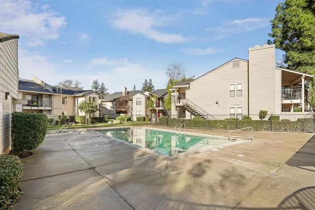 a front view of a house with a yard and potted plants