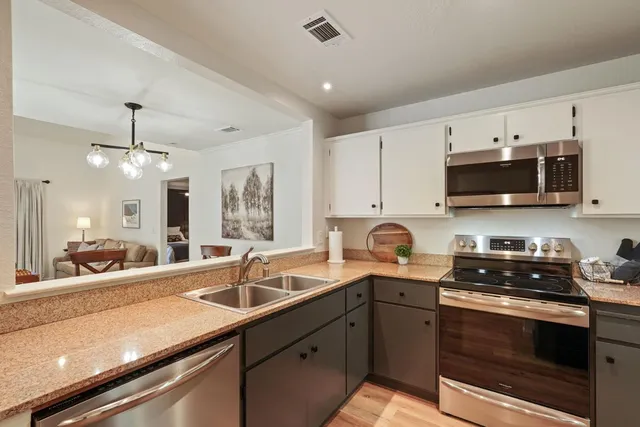 a kitchen with stainless steel appliances granite countertop a sink stove and refrigerator