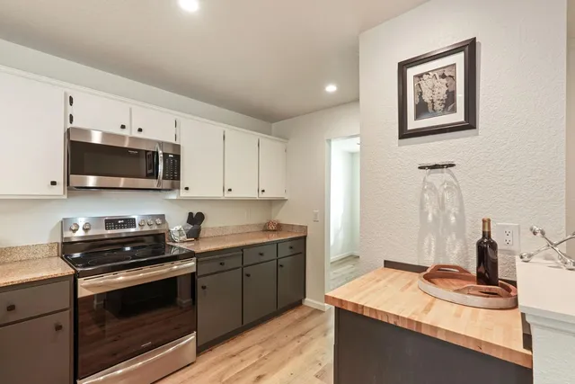 a kitchen with stainless steel appliances a sink a stove and microwave