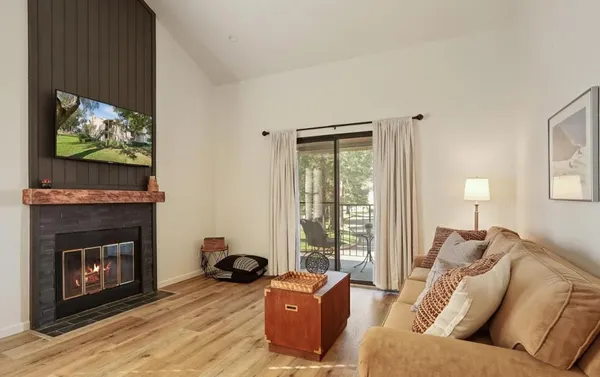 a living room with furniture a flat screen tv and a fireplace