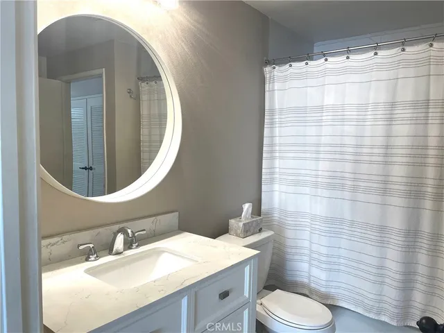 a bathroom with a sink vanity mirror and toilet