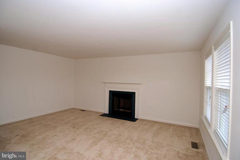 74 Shelby Road Inwood, WV 25428 - Photo 12 of 27 an empty room with a fireplace and windows