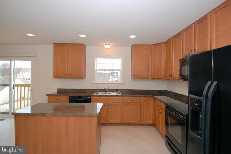 74 Shelby Road Inwood, WV 25428 - Photo 8 of 27 a kitchen with stainless steel appliances granite countertop a refrigerator a sink dishwasher a stove and white countertops with wooden floor