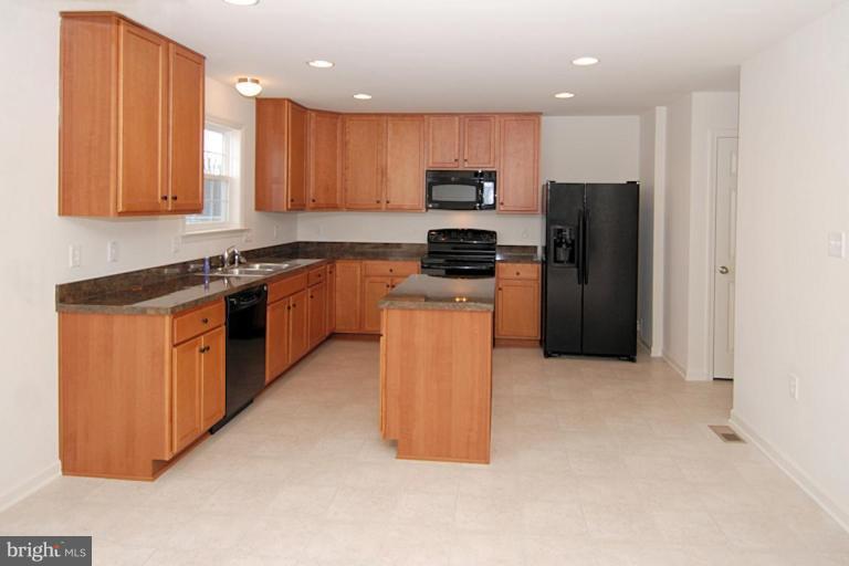 74 Shelby Road Inwood, WV 25428 - Photo 9 of 27 a kitchen with stainless steel appliances granite countertop a stove refrigerator sink and microwave