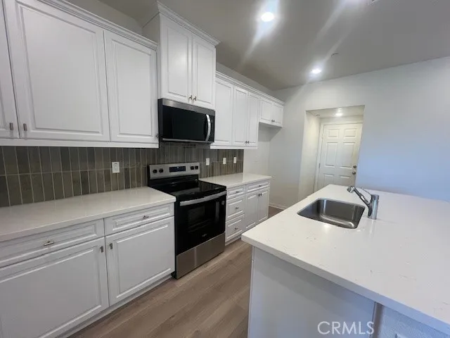 a kitchen with a sink and white cabinets