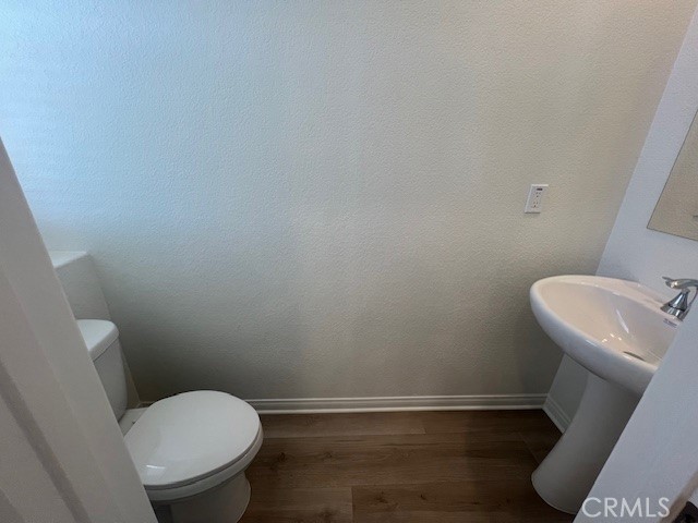 4235 East Rincon Street Ontario, CA 91761 - Photo 8 of 40 a white toilet sitting next to a small sink