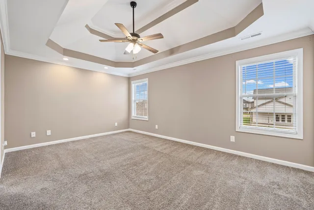 an empty room with windows and fan