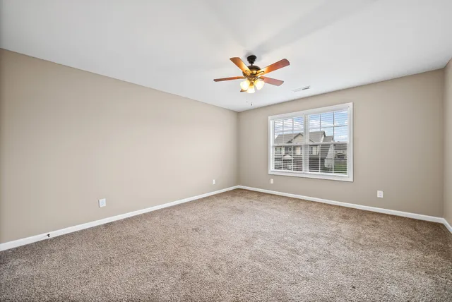 an empty room with closet and a chandelier fan