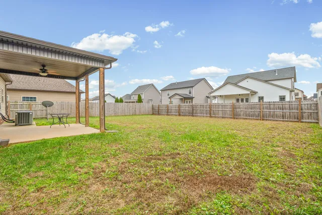 a view of a house with a big yard and large tree