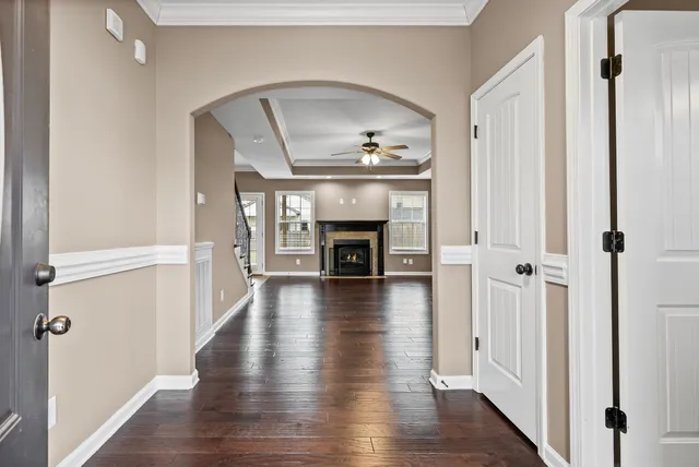 a view of an empty room with wooden floor fireplace and a window
