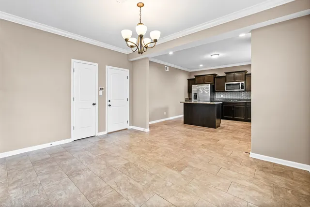 a view of a kitchen with stainless steel appliances granite countertop a refrigerator and a stove top oven