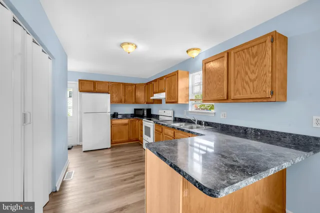 a kitchen with stainless steel appliances granite countertop a sink a stove and a refrigerator