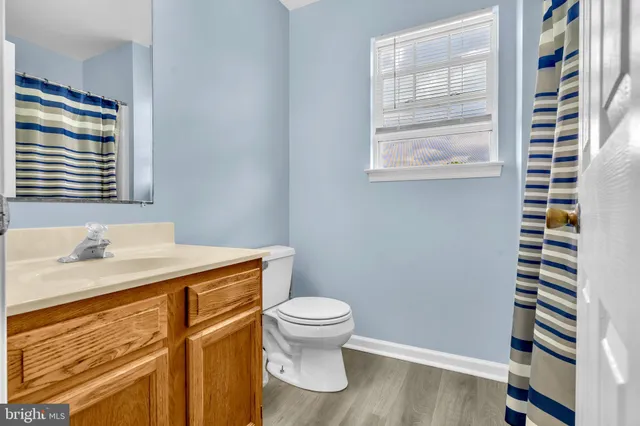 a bathroom with a sink a toilet and a window