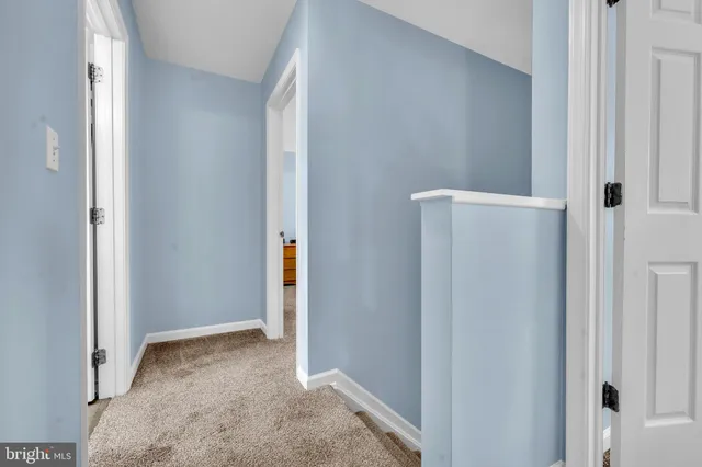 a white bed sitting in a room next to a window