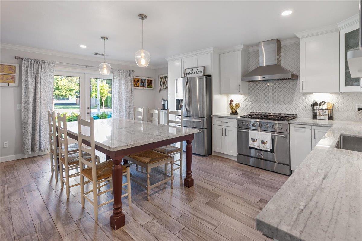 751 Eschenburg Drive Gilroy, CA 95020 - Photo 19 of 39 a kitchen with stainless steel appliances wooden floor dining table and chairs