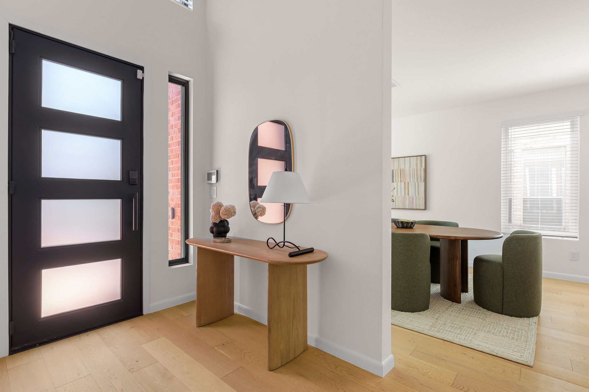 6500 Clay Allison Pass Austin, TX 78749 - Photo 6 of 39 Entryway featuring a modern black front door with frosted glass panels, wood-finish flooring, and a vertical window
