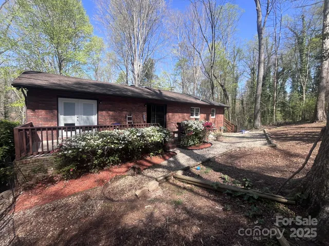 a view of house with yard and a tree