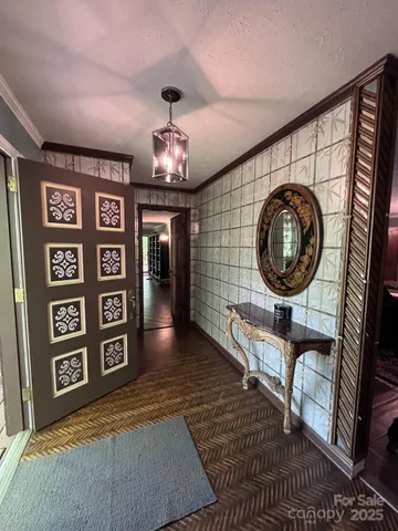 a view of a hallway with wooden floor and furniture