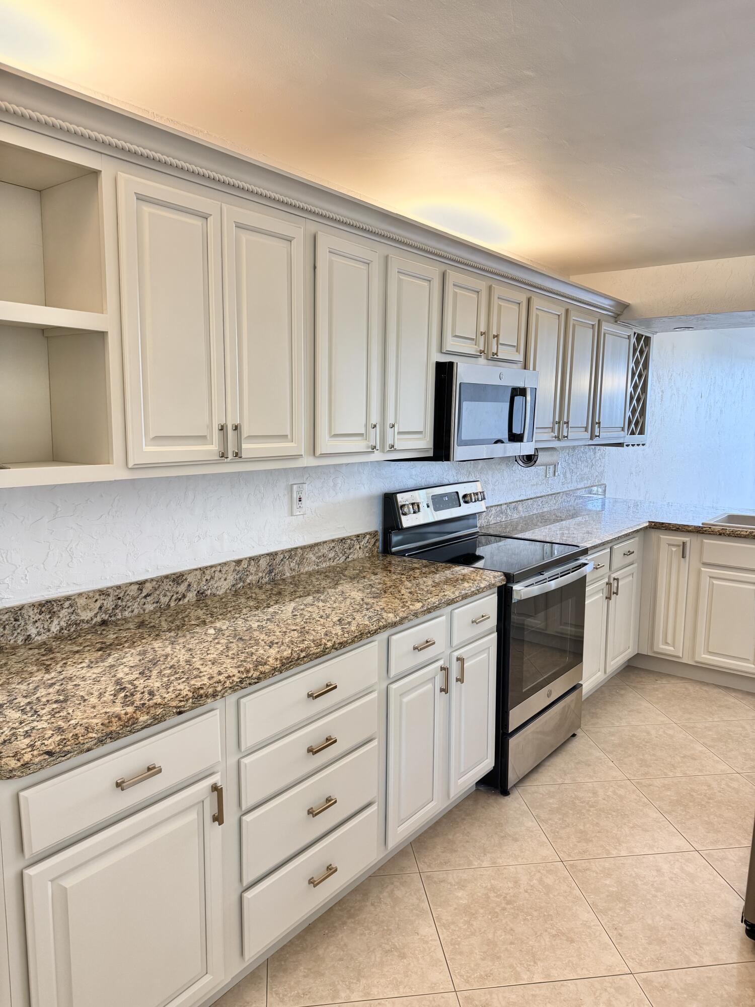 13 Royal Palm Way, Unit 302 Boca Raton, FL 33432 - Photo 2 of 31 a kitchen with granite countertop white cabinets white stainless steel appliances with a sink and dishwasher