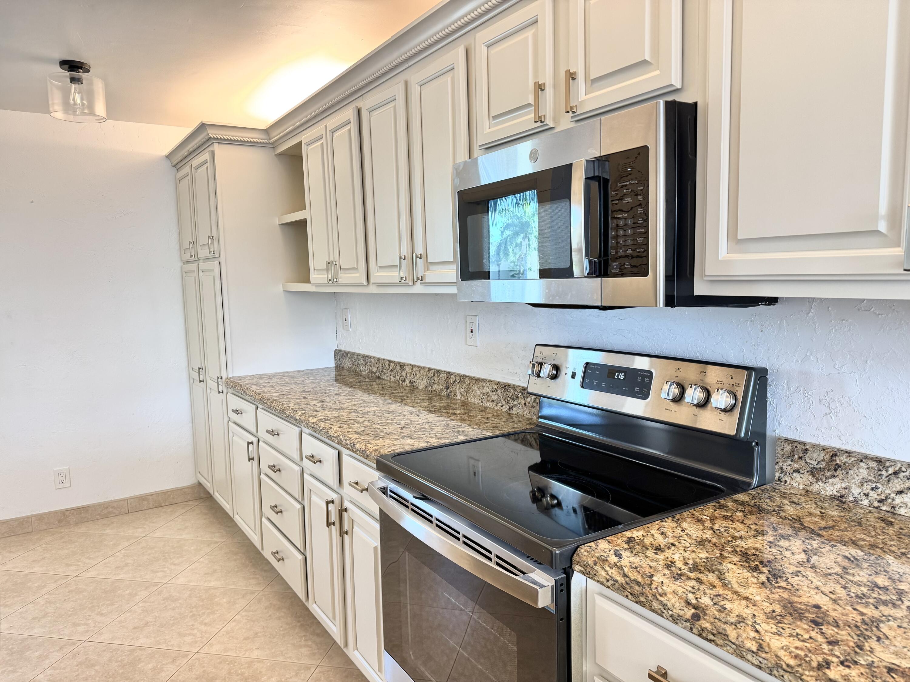 13 Royal Palm Way, Unit 302 Boca Raton, FL 33432 - Photo 3 of 31 a kitchen with granite countertop a stove and a sink