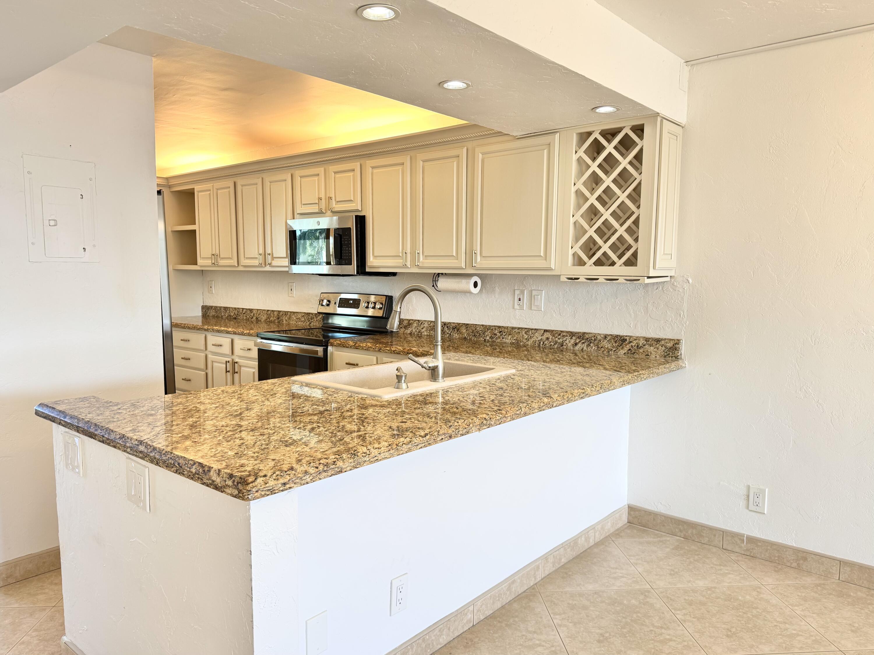 13 Royal Palm Way, Unit 302 Boca Raton, FL 33432 - Photo 5 of 31 a kitchen with stainless steel appliances granite countertop a sink and a refrigerator