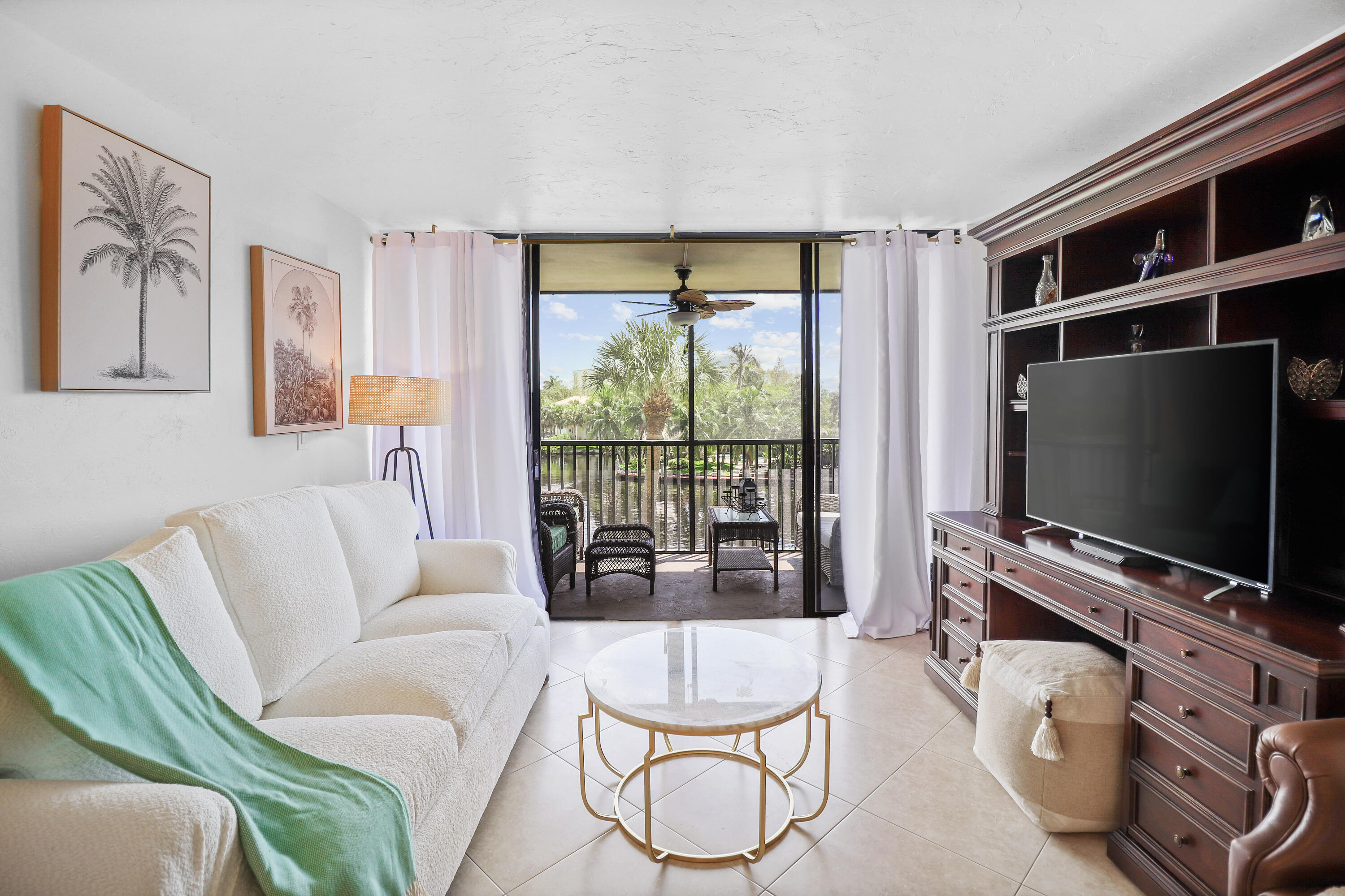 13 Royal Palm Way, Unit 302 Boca Raton, FL 33432 - Photo 9 of 31 a living room with furniture a flat screen tv and a floor to ceiling window