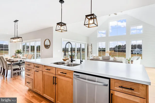 a kitchen with stainless steel appliances kitchen island granite countertop a sink stove and white cabinets