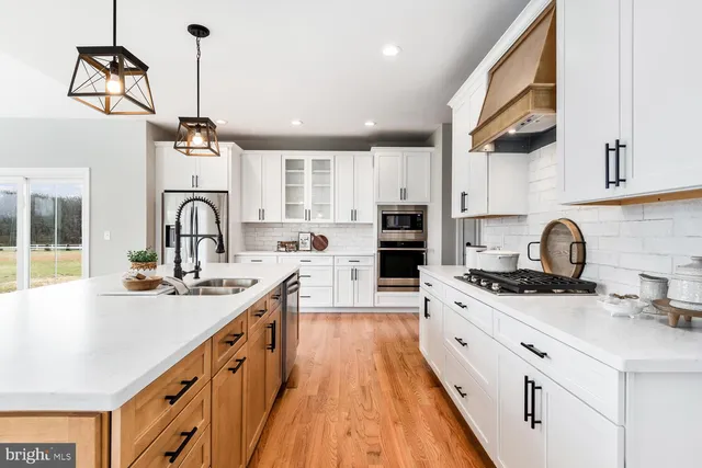 a kitchen with a sink a stove and a wooden floor