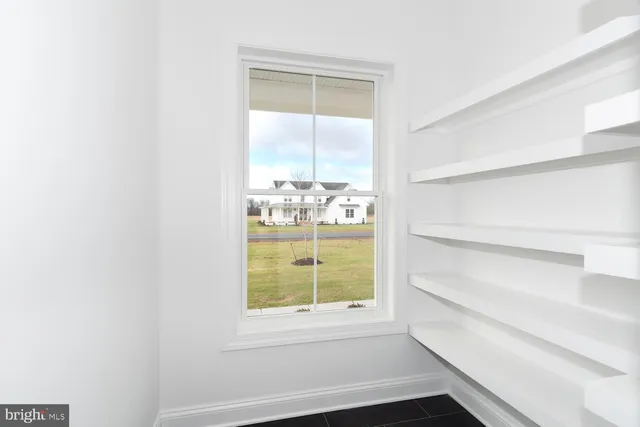an empty room with windows and ceiling fan