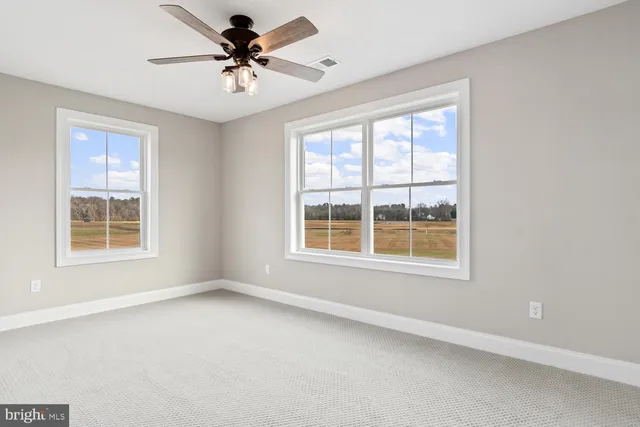 an empty room with a chandelier fan