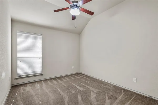 an empty room with a window and a fan