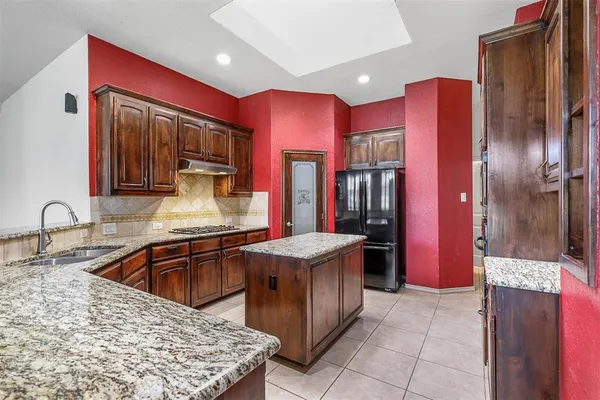 a kitchen with stainless steel appliances granite countertop a refrigerator and a sink