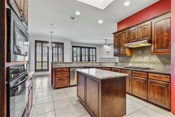 a kitchen with granite countertop a sink stove and cabinets