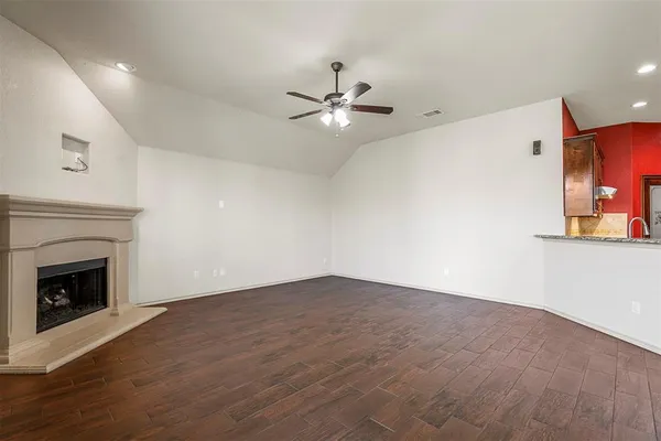 an empty room with fan and fireplace