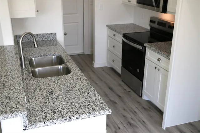a kitchen with granite countertop a sink and a stove top oven